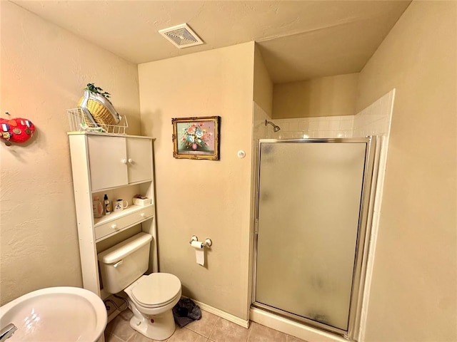full bathroom featuring tile patterned floors, a stall shower, and toilet