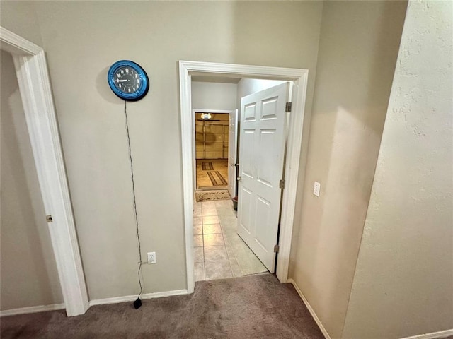 hallway with light colored carpet and baseboards
