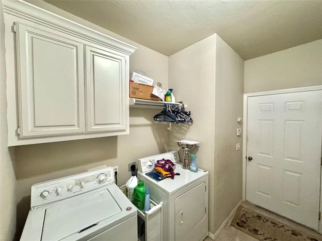 washroom with independent washer and dryer, cabinet space, and light tile patterned floors