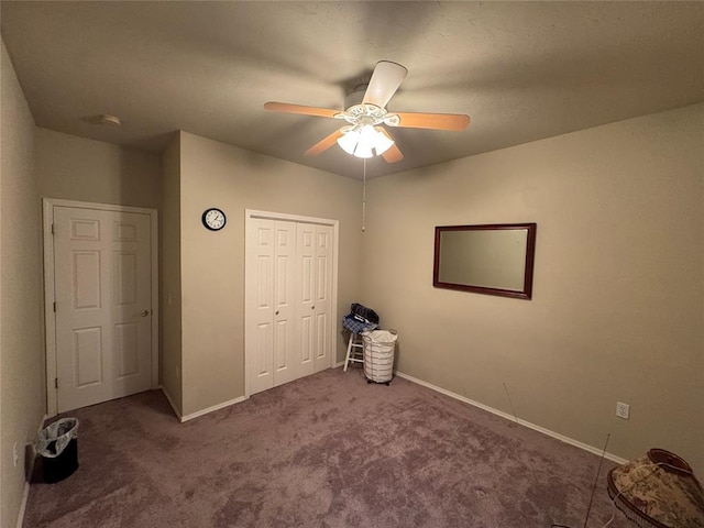 unfurnished bedroom with carpet floors, a closet, baseboards, and ceiling fan