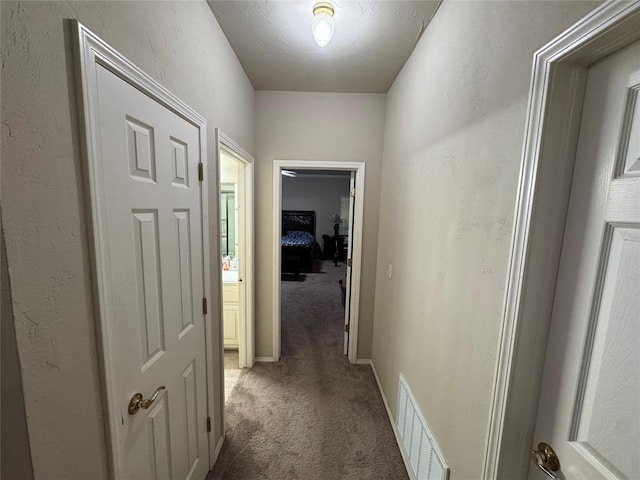 hall featuring carpet and baseboards