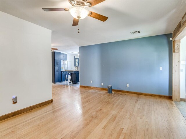 3208 NW 34th St, Oklahoma City, OK 73112 - unfurnished living room with a ceiling fan, light wood-style floors, and baseboards