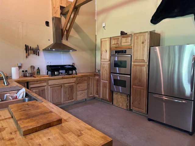 377056 E 1040th Rd, Okemah, OK 74859 - kitchen featuring stainless steel appliances, wall chimney exhaust hood, butcher block countertops, and a sink