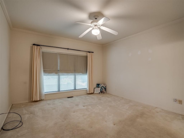 empty room featuring crown molding, carpet floors, ceiling fan, and baseboards