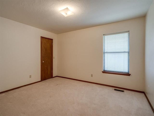 unfurnished room with light colored carpet and baseboards