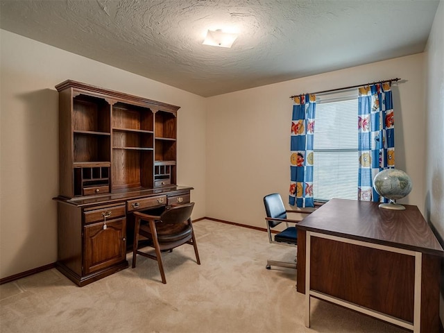 office featuring light colored carpet, baseboards, and a textured ceiling