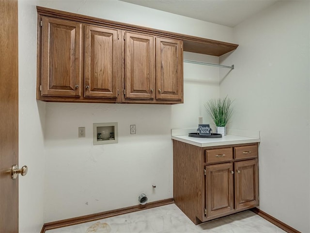 washroom with cabinet space, washer hookup, light marble finish flooring, and baseboards