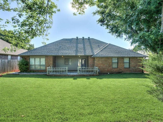 back of property featuring brick siding and a shingled roof