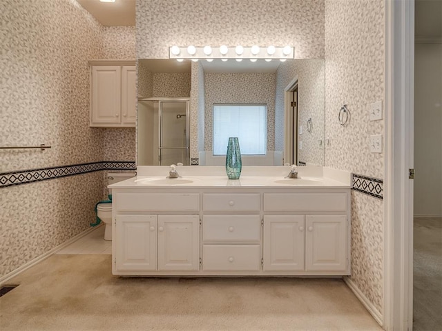 full bath with wallpapered walls, a shower stall, double vanity, and toilet