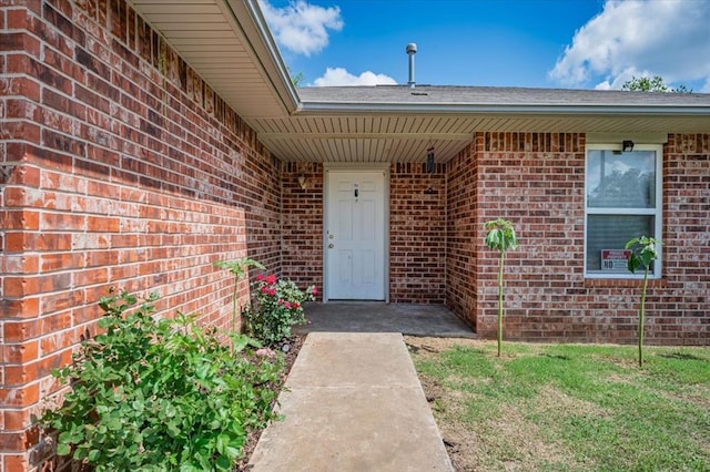 entrance to property featuring brick siding