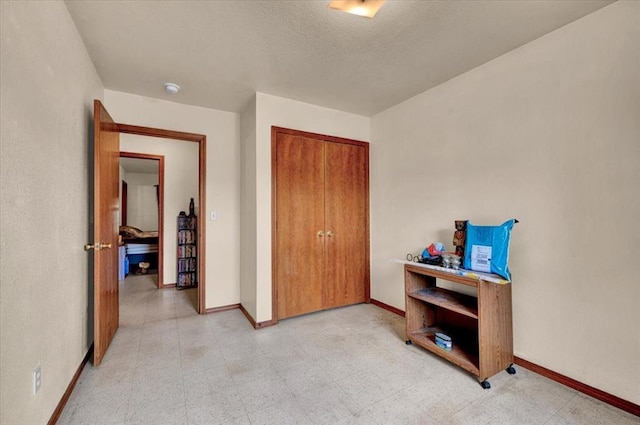 bedroom featuring baseboards, a closet, and light floors