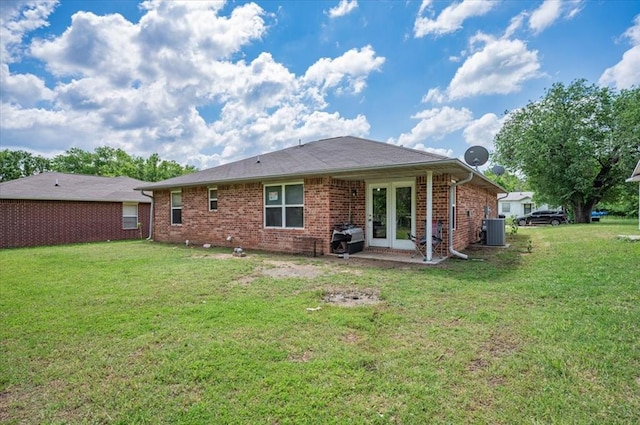 back of property featuring central AC, french doors, a yard, and brick siding