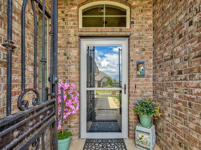 view of exterior entry featuring brick siding