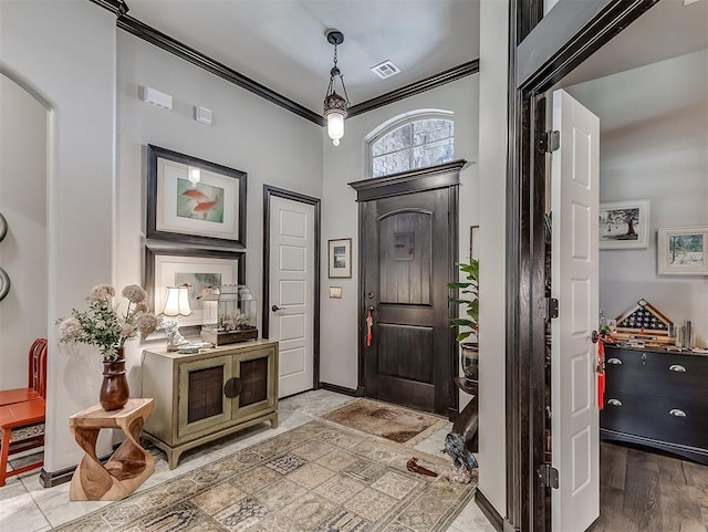 entrance foyer featuring ornamental molding and baseboards