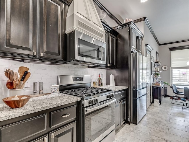 kitchen featuring appliances with stainless steel finishes, ornamental molding, backsplash, light stone countertops, and light tile patterned floors