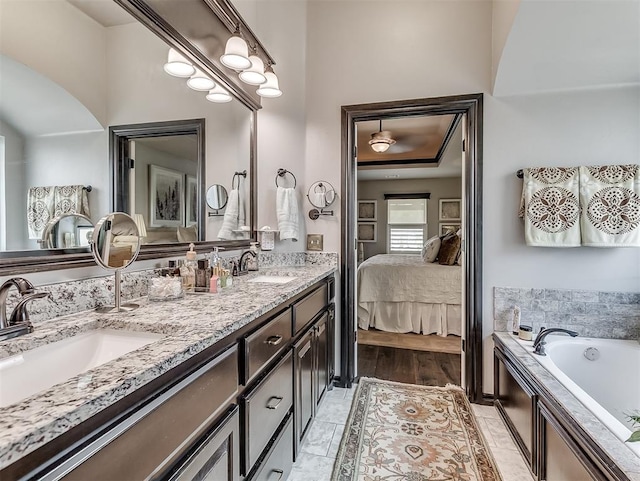 bathroom with connected bathroom, double vanity, and a bath