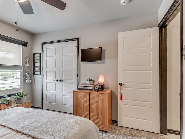 bedroom featuring a closet, light colored carpet, and ceiling fan