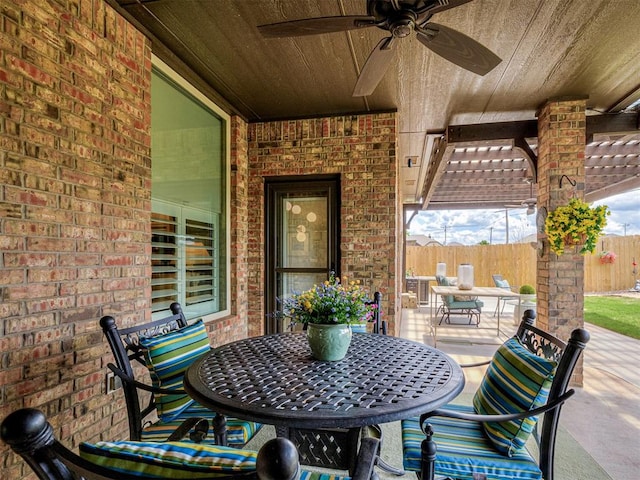 view of patio featuring fence, ceiling fan, and outdoor dining space