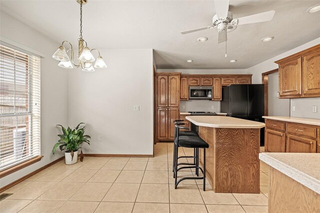 8109 Dawn Cir, Oklahoma City, OK 73135 - kitchen with stainless steel microwave, light countertops, a ceiling fan, a kitchen bar, and a center island