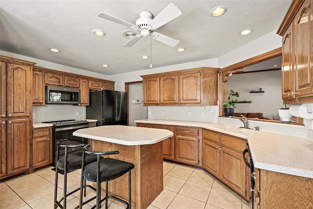 8109 Dawn Cir, Oklahoma City, OK 73135 - kitchen with stainless steel microwave, freestanding refrigerator, a sink, light tile patterned floors, and recessed lighting