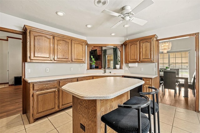 8109 Dawn Cir, Oklahoma City, OK 73135 - kitchen with dishwasher, light countertops, a kitchen island, a ceiling fan, and a breakfast bar