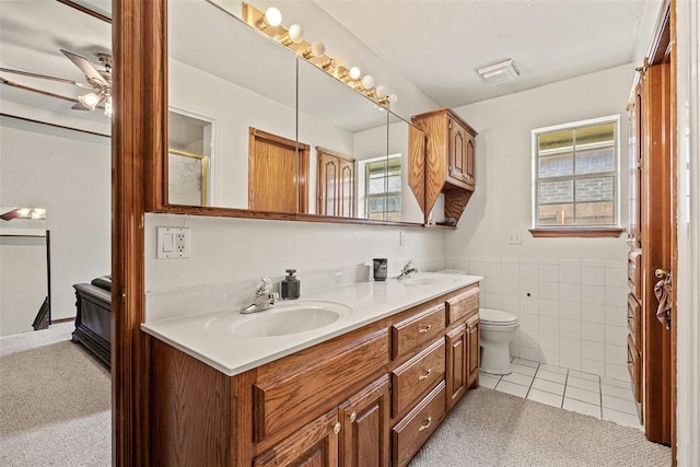 8109 Dawn Cir, Oklahoma City, OK 73135 - bathroom featuring a ceiling fan, plenty of natural light, double vanity, tile patterned flooring, and tile walls
