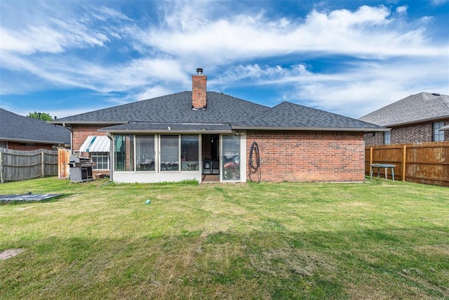 8109 Dawn Cir, Oklahoma City, OK 73135 - back of house with brick siding, a sunroom, a chimney, and roof with shingles