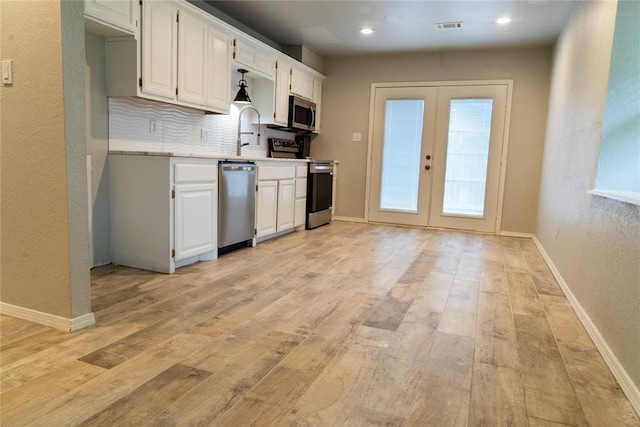 201 Lois Ave, Tuttle, OK 73089 - kitchen featuring appliances with stainless steel finishes, french doors, light countertops, light wood-type flooring, and recessed lighting