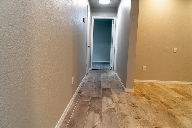 201 Lois Ave, Tuttle, OK 73089 - hallway with light wood-style flooring, a textured wall, and baseboards