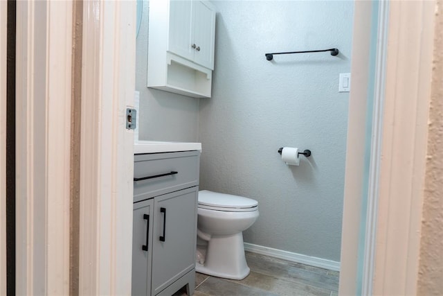 201 Lois Ave, Tuttle, OK 73089 - bathroom with toilet, vanity, wood finished floors, and baseboards
