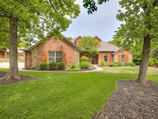 3570 Riverwood Ln, Edmond, OK 73034 - traditional-style house featuring stone siding and a front lawn