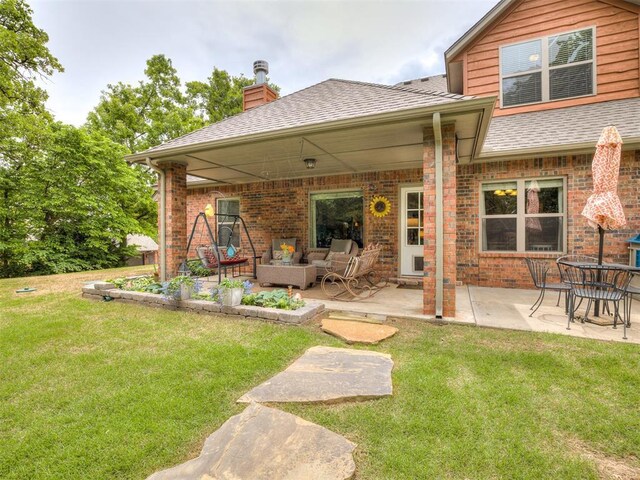 3570 Riverwood Ln, Edmond, OK 73034 - rear view of house featuring a lawn, a patio area, brick siding, and a chimney