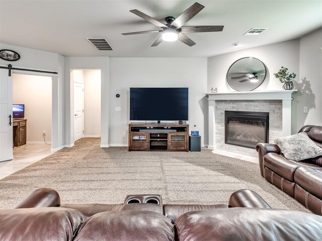 10301 NW 25th St, Yukon, OK 73099 - living room featuring a ceiling fan, a glass covered fireplace, a barn door, carpet flooring, and baseboards