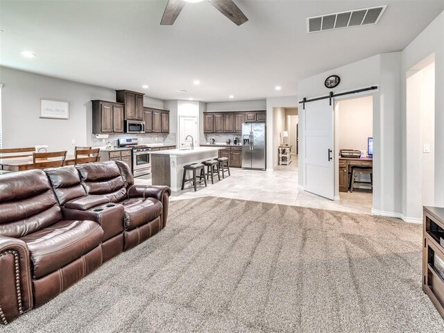 10301 NW 25th St, Yukon, OK 73099 - living area with a barn door, light colored carpet, ceiling fan, recessed lighting, and baseboards