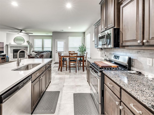 10301 NW 25th St, Yukon, OK 73099 - kitchen with stainless steel appliances, a sink, ceiling fan, backsplash, and open floor plan