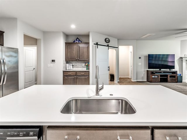 10301 NW 25th St, Yukon, OK 73099 - kitchen featuring a sink, open floor plan, dishwasher, light countertops, and dark brown cabinetry