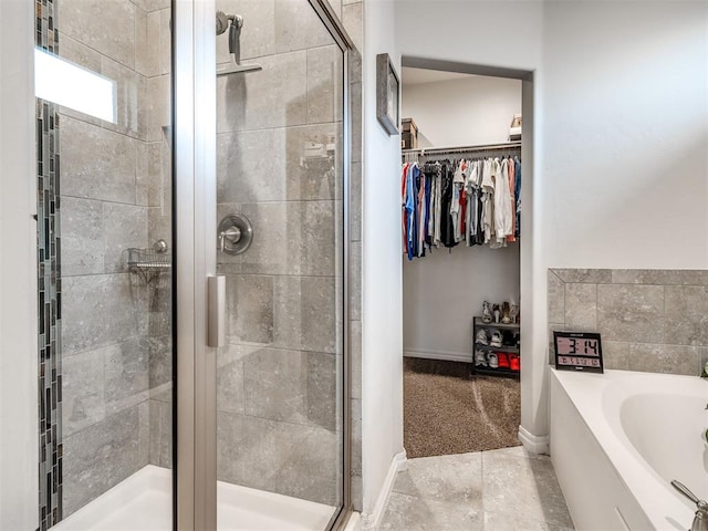 10301 NW 25th St, Yukon, OK 73099 - full bathroom featuring a stall shower, a garden tub, a spacious closet, and tile patterned floors
