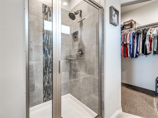 10301 NW 25th St, Yukon, OK 73099 - bathroom with a shower stall, a spacious closet, and baseboards