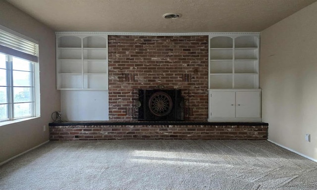 unfurnished living room with carpet, healthy amount of natural light, baseboards, and a textured ceiling