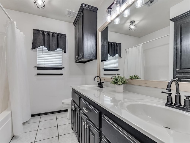 4900 Republic Dr, Oklahoma City, OK 73135 - bathroom featuring healthy amount of natural light, tile patterned flooring, toilet, and double vanity