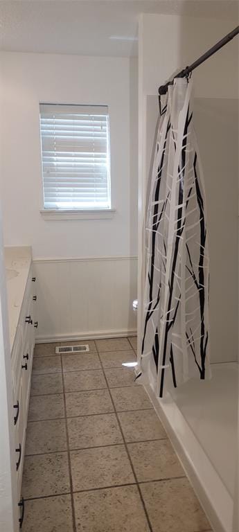 full bathroom with baseboards, curtained shower, vanity, and tile patterned floors