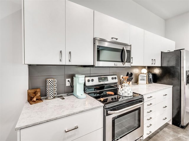 kitchen featuring stainless steel appliances, tasteful backsplash, light stone countertops, and white cabinetry