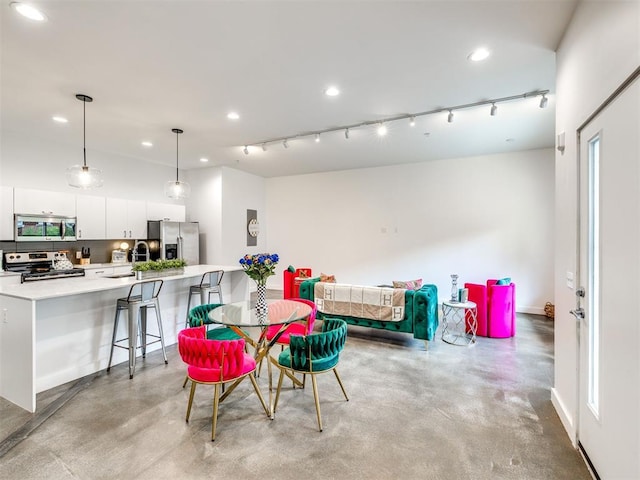 dining room with finished concrete floors, recessed lighting, and rail lighting