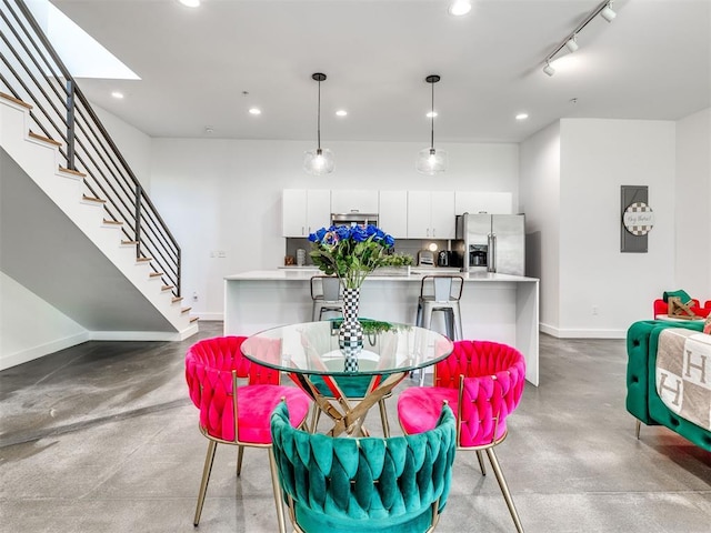 dining room featuring baseboards, finished concrete flooring, recessed lighting, and stairs