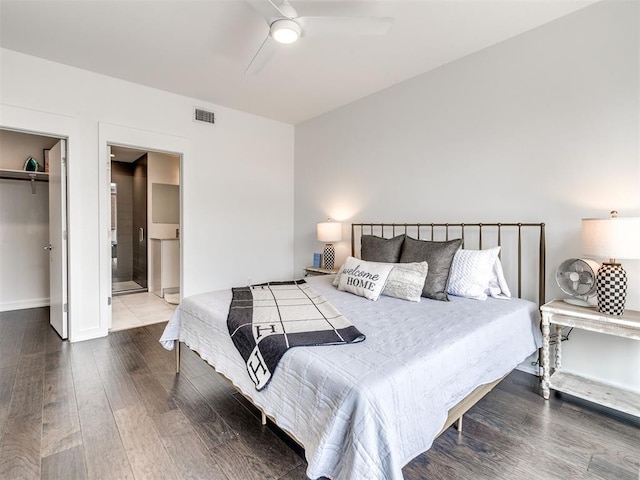 bedroom featuring wood finished floors, a walk in closet, baseboards, and a closet