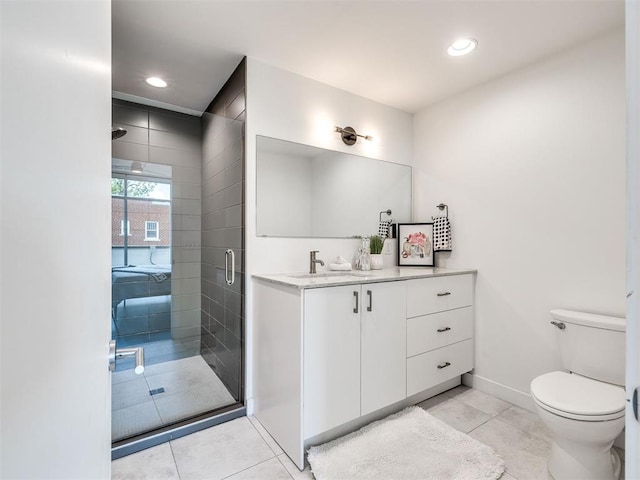bathroom with toilet, a shower stall, tile patterned flooring, vanity, and baseboards