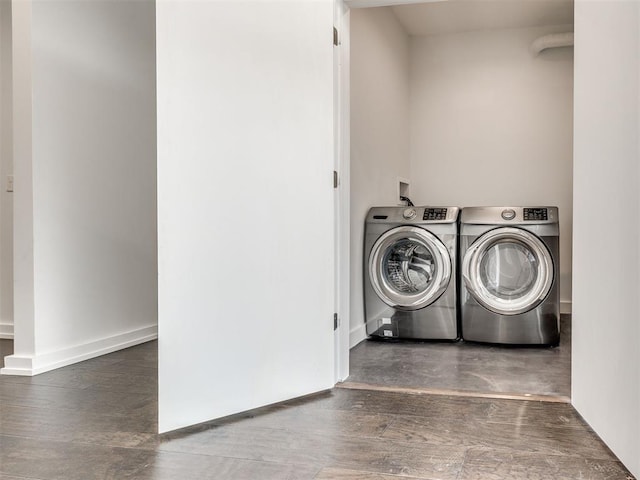 laundry area featuring independent washer and dryer, wood finished floors, and baseboards