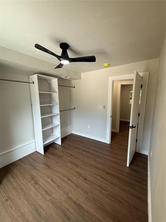 1212 NW 48th St, Oklahoma City, OK 73118 - unfurnished bedroom with dark wood finished floors, baseboards, and ceiling fan