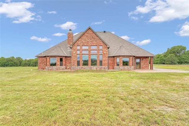 21698 SW Coombs Rd, Cache, OK 73527 - rear view of house featuring a chimney, brick siding, a lawn, and a shingled roof
