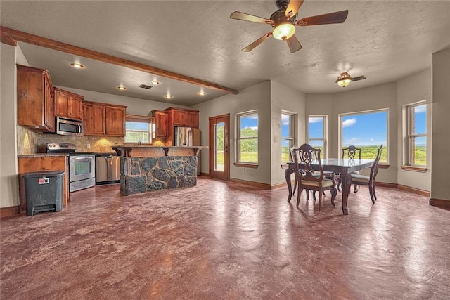 21698 SW Coombs Rd, Cache, OK 73527 - kitchen with stainless steel appliances, baseboards, decorative backsplash, a textured ceiling, and concrete floors